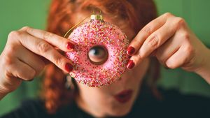 Frau schaut durch eine Donut-Weihnachtskugel - Foto: LECKER.de/Nicole Molitor