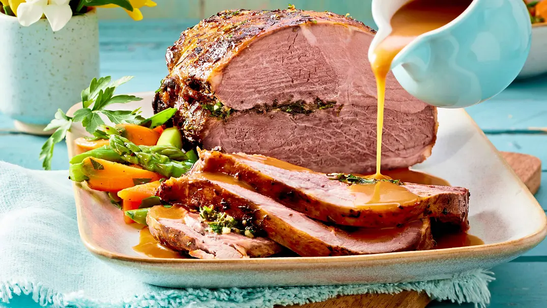 Angeschnittener Lammkeulen-Braten, auf den braune Soße aus einem Kännchen gegossen wird - Foto: LECKER @ Bauer Media Group Angeschnittener Lammkeulen-Braten, auf den braune Soße aus einem Kännchen gegossen wird - Foto: LECKER @ Bauer Media Group