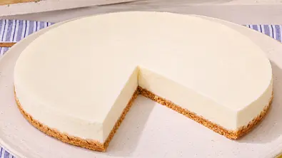 Buttermilch-Zitronentorte mit Zwiebackboden steht angeschnitten auf einer Servierplatte - Foto: LECKER @ Bauer Media Group