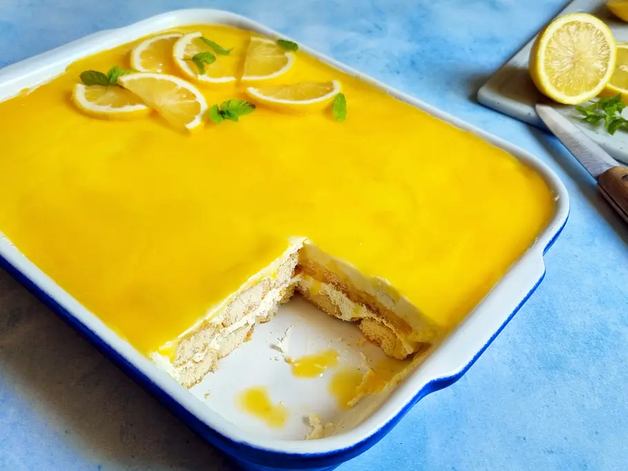 Zitronen-Tiramisu Rezept Zitronen-Tiramisu mit gelben Lemon Curd-Topping in einer großen Auflaufform serviert.