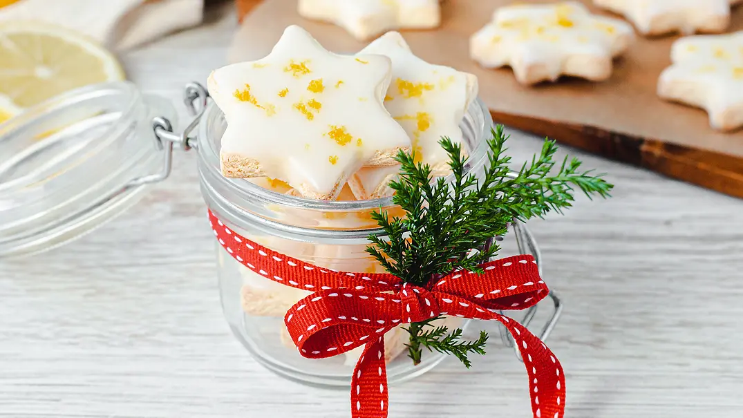 Zitronensterne mit Zuckerguss und Zitronenzesten in einem kleinen, als Geschenk dekorierten Weckglas mit Bügelverschluss. - Foto: ShowHeroes für LECKER @ Bauer Media Group Zitronensterne mit Zuckerguss und Zitronenzesten in einem kleinen, als Geschenk dekorierten Weckglas mit Bügelverschluss. - Foto: ShowHeroes für LECKER @ Bauer Media Group