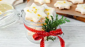 Zitronensterne mit Zuckerguss und Zitronenzesten in einem kleinen, als Geschenk dekorierten Weckglas mit Bügelverschluss. - Foto: ShowHeroes für LECKER @ Bauer Media Group Zitronensterne mit Zuckerguss und Zitronenzesten in einem kleinen, als Geschenk dekorierten Weckglas mit Bügelverschluss. - Foto: ShowHeroes für LECKER @ Bauer Media Group