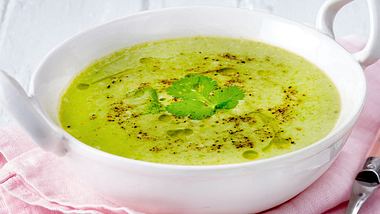 Zucchinisuppe in einer großen weißen Schüssel.Gemahlener Pfeffer und ein Petersilienblatt sind auf der Suppe zu sehen. - Foto: House of Food / Bauer Food Experts KG