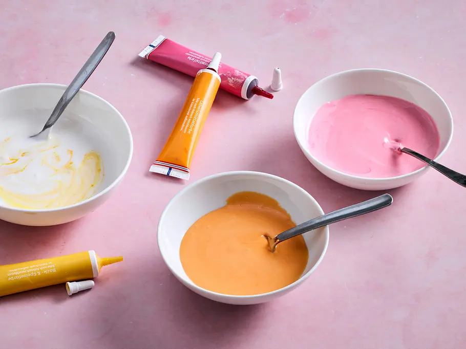Zuckerguss pastellig einfärben Drei Schüsseln mit eingefärbten Zuckerguss in pastellfarben sind zu erkennen.